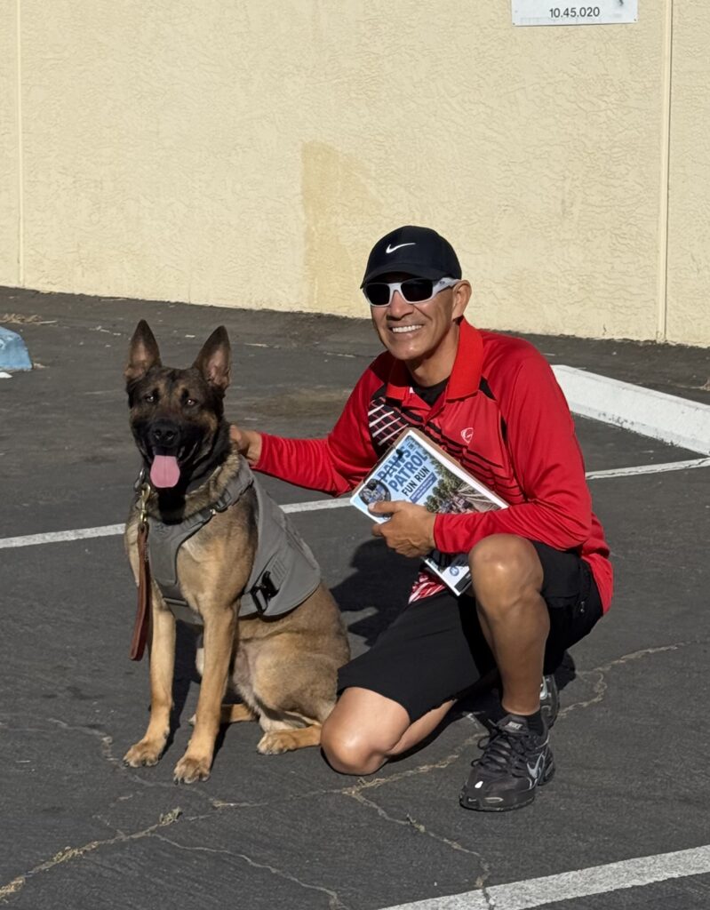Al Garcia of Alpha-Ro Race Timing with a Merced Police K-9 at the Paws on Patrol Fun Run